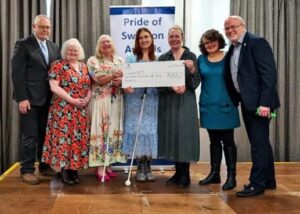Photograph of bats members in Andrea Allison Becky and Cheryl. Receiving their make a difference award alongside Mark flay from Zurich also in the photo is a large check for £1, 250 which was one by the bats alongside the Pride of Swindon award.